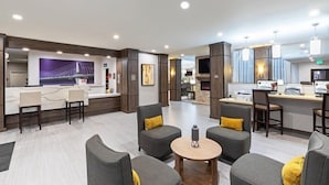 A modern hotel lobby with a reception desk, seating area, and a bar. - Suite w/ 2 Qn Beds Nr IAH Airport | Free Breakfast (Houston)