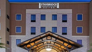 Staybridge Suites building with a modern entrance, multiple windows, and a stone facade. - Suite w/ 2 Qn Beds Nr IAH Airport | Free Breakfast (Houston)