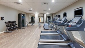 Un gimnasio con cintas de correr, mancuernas y equipamiento de ejercicio.