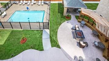 A pool area with lounge chairs and a barbecue.