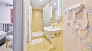 A bathroom with a sink, mirror, hairdryer, and shower. - Hotel Bouda Jana (Pec pod Sněžkou)