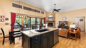 A spacious kitchen with a large island, dining area, and a fireplace.