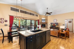 A spacious kitchen with a large island, dining area, and a fireplace. - Mountain Retreat w/ patio | Near downtown (Show Low)