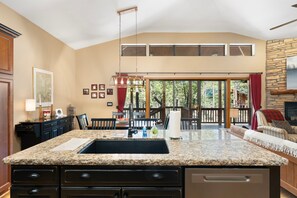 A kitchen with a granite countertop, a large island, and a dining area with a view of the outdoors. - Mountain Retreat w/ patio | Near downtown (Show Low)