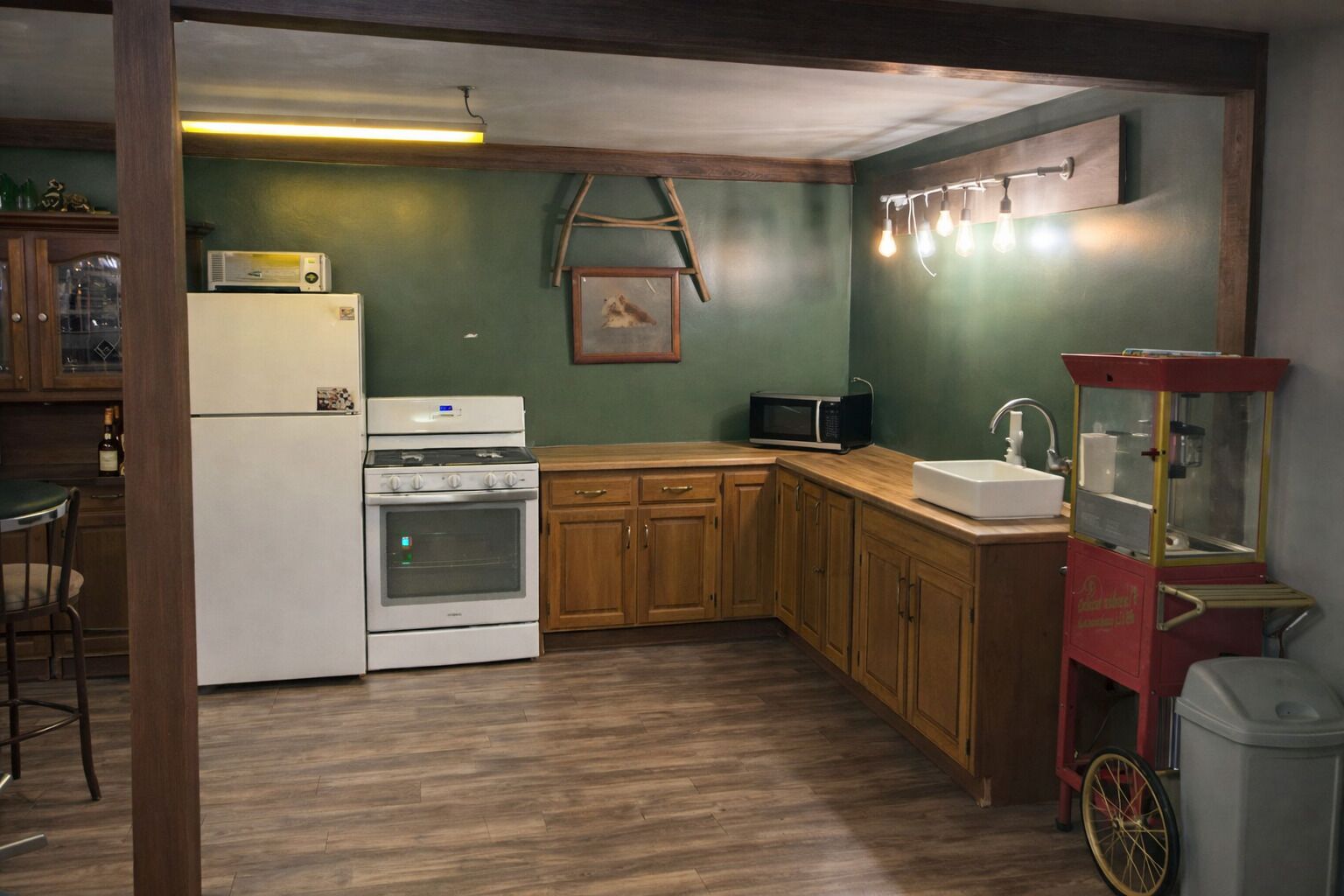 A kitchen with wooden cabinets, a white refrigerator, a stove, a microwave, and a sink.