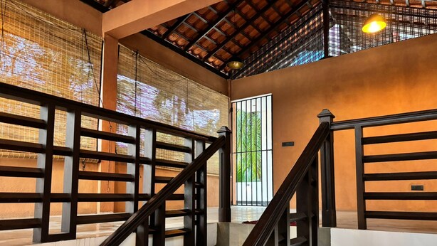Una scala con ringhiere in legno e un soffitto a griglia.