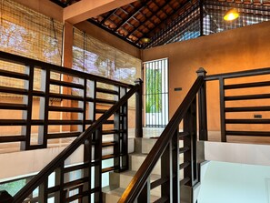 Una escalera con barandillas de madera y techo con diseño de cuadrícula.