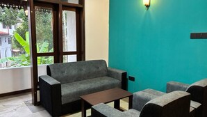 Una stanza con un divano, un tavolino da caffè e una parete decorata in tonalità verde acqua.