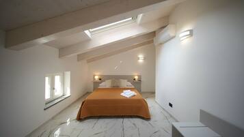 Une chambre à coucher avec un lit, une lucarne, des lampes de chevet et une fenêtre.
