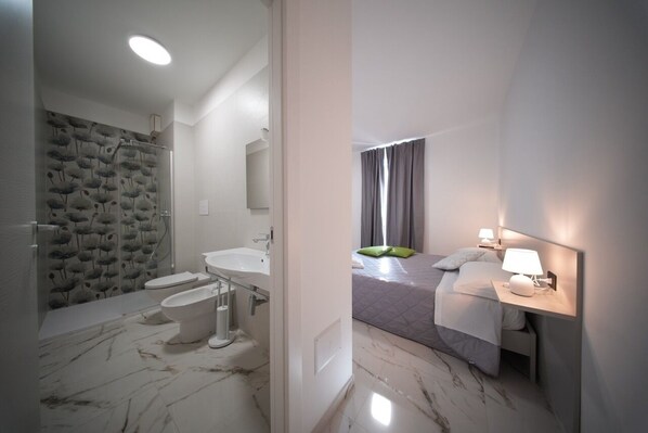 A modern bathroom with a shower, toilet, and sink.