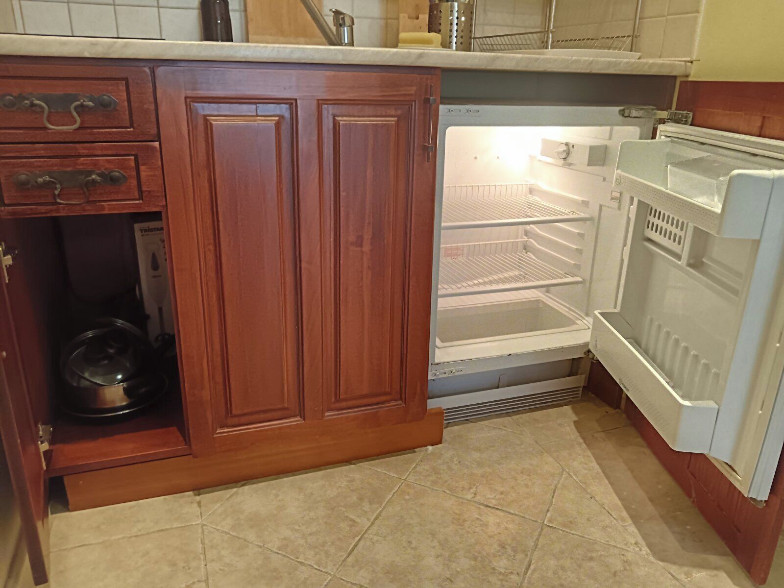 Eine Küche mit Holzausstattung, Backofen und Kühlschrank.