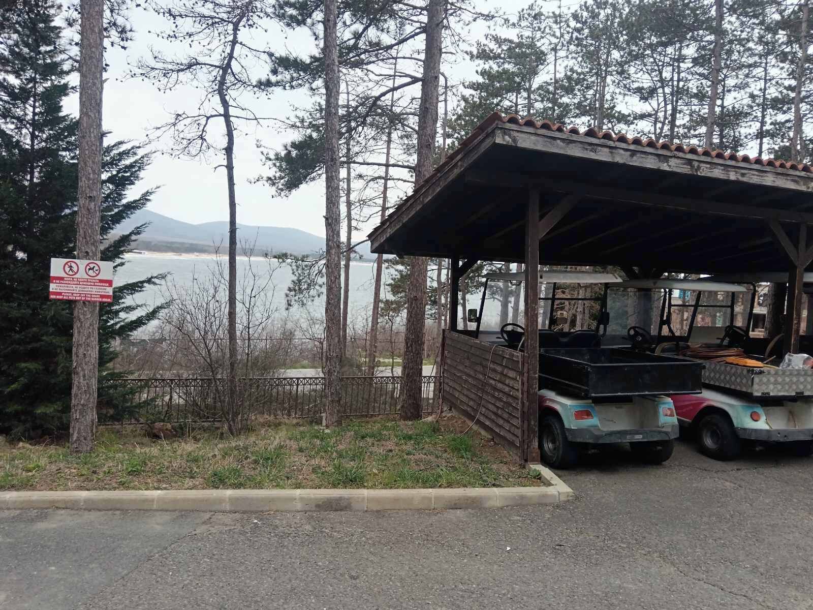 Eine rustikale Holzhütte mit Vordach, einem Wagen und einem Schild, das ein Parkverbot anzeigt.