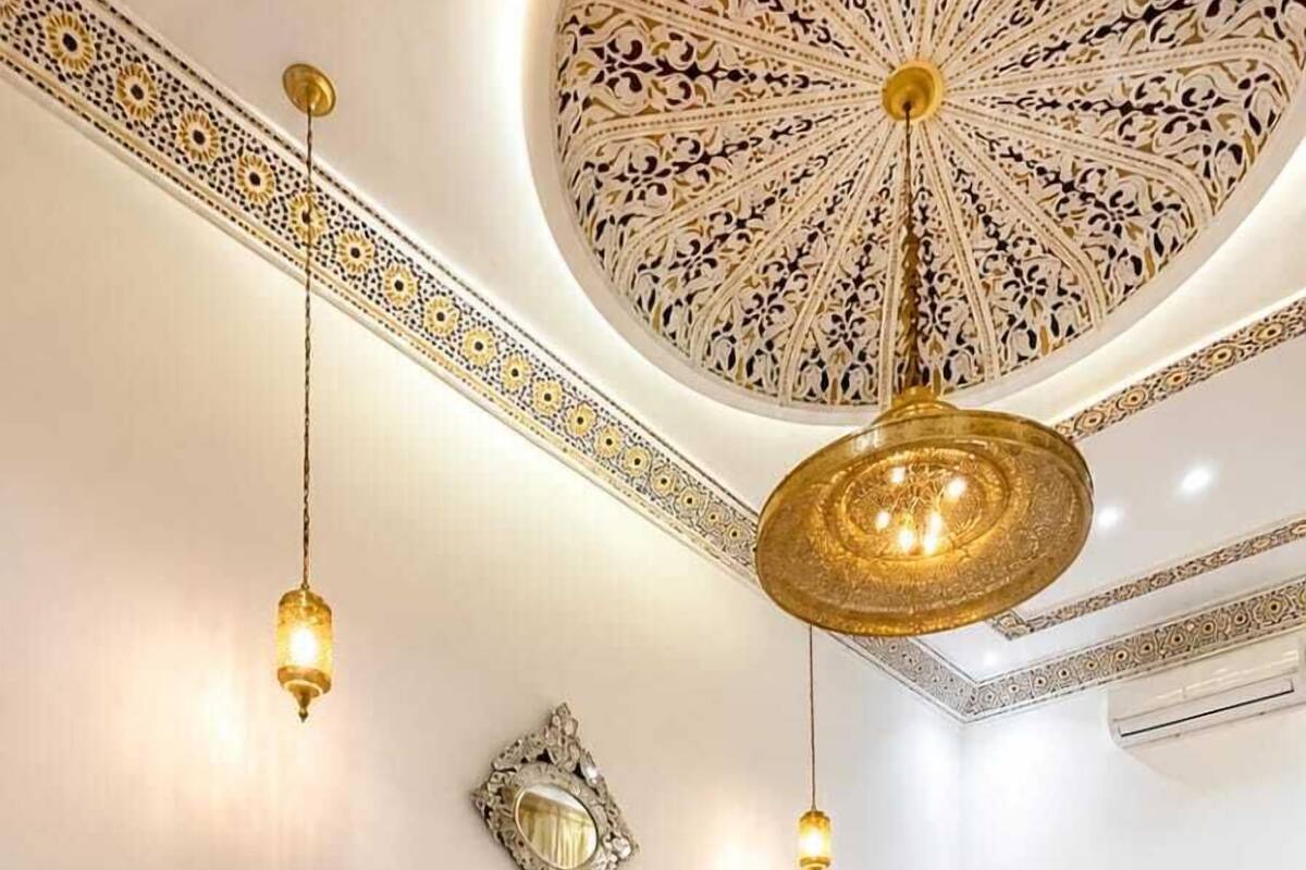 Ein Schlafzimmer mit einem großen Bett, einem Nachttisch, einem Spiegel und einer Hängeleuchte.