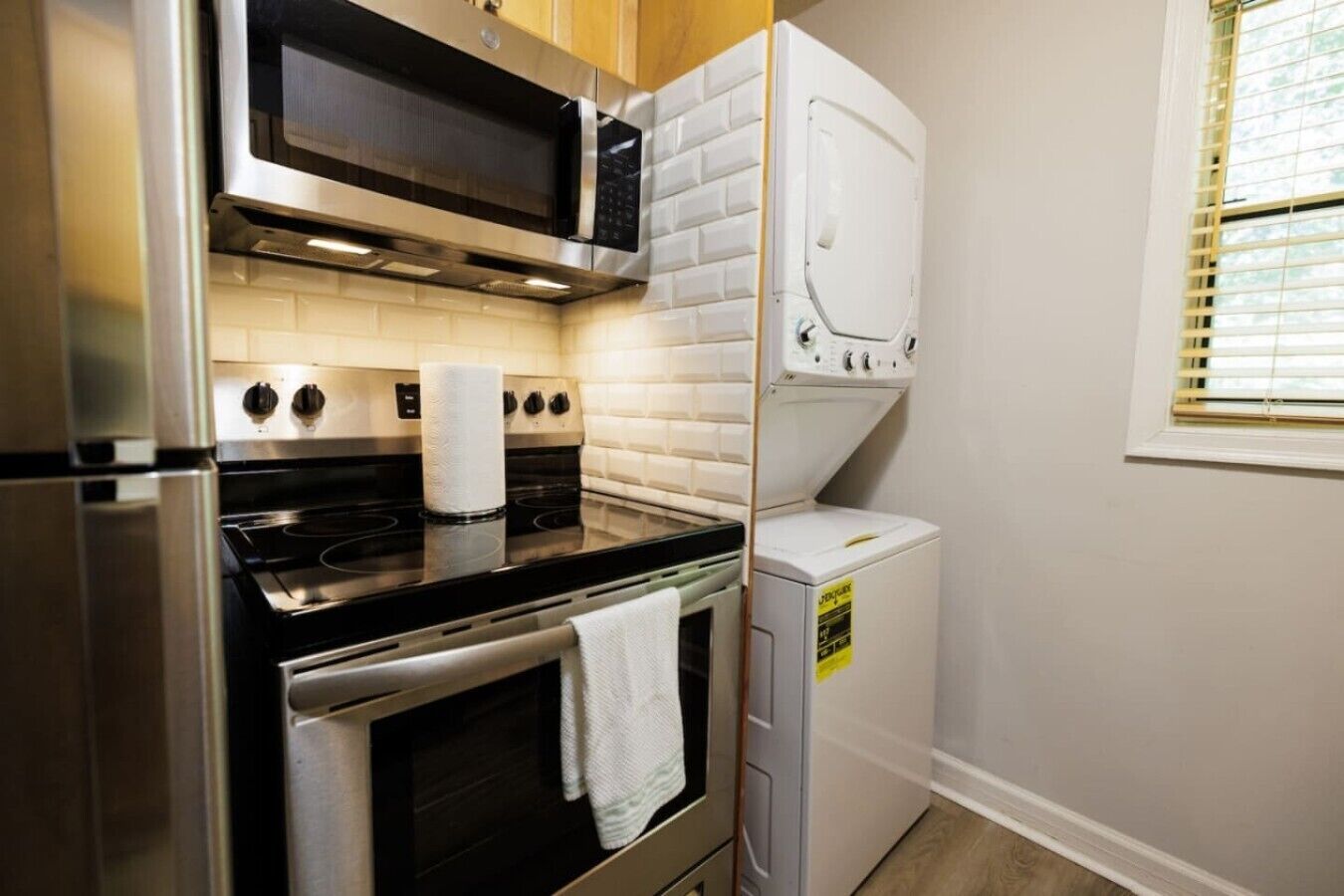 A compact kitchen with a microwave, stove, oven, and a washing machine.
