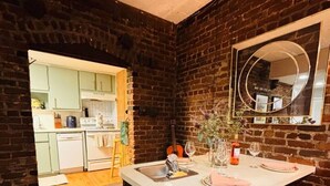 A kitchen with a central island, a sink, and a mirror above it. There is a dining area with a table and chairs. - Ground floor flat at Virginia Highlands (Atlanta)