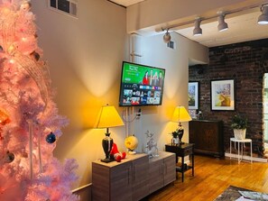 A living room with a television, a Christmas tree, and a fireplace. - Ground floor flat at Virginia Highlands (Atlanta)