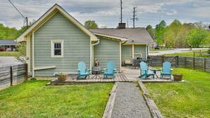 Een huis met een veranda, zitplaatsen buiten en een kleine tuin.
