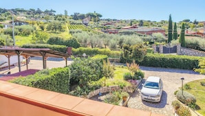 Zona residencial con un camino de entrada pavimentado, un coche estacionado y una estructura de pérgola.