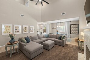 A spacious living room with a sectional sofa, a dining area, and a kitchen in the background. - Desert Sky Escape in Marana (Marana)