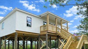 A two-story house with a wooden deck and a staircase. - Lux home, walkable to priv beach, near marina, golf in Gulf Shores Fort Morgan (Gulf Shores)
