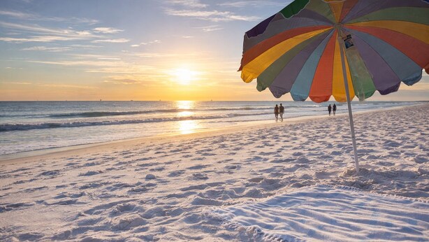 A beach with a colorful umbrella and footprints in the sand. - Lux home, walkable to priv beach, near marina, golf in Gulf Shores Fort Morgan (Gulf Shores)