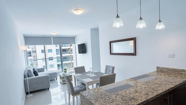 Apartamento moderno com área de jantar, cozinha e sala de estar.