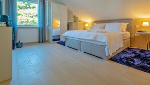 A bedroom with a bed, a nightstand, a lamp, a window with curtains, and a ceiling light fixture. - Stay With Panoramic Sea Views (Pucisca)