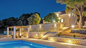 A swimming pool with a pergola, stone walls, and steps leading to a house. - Stay With Panoramic Sea Views (Pucisca)