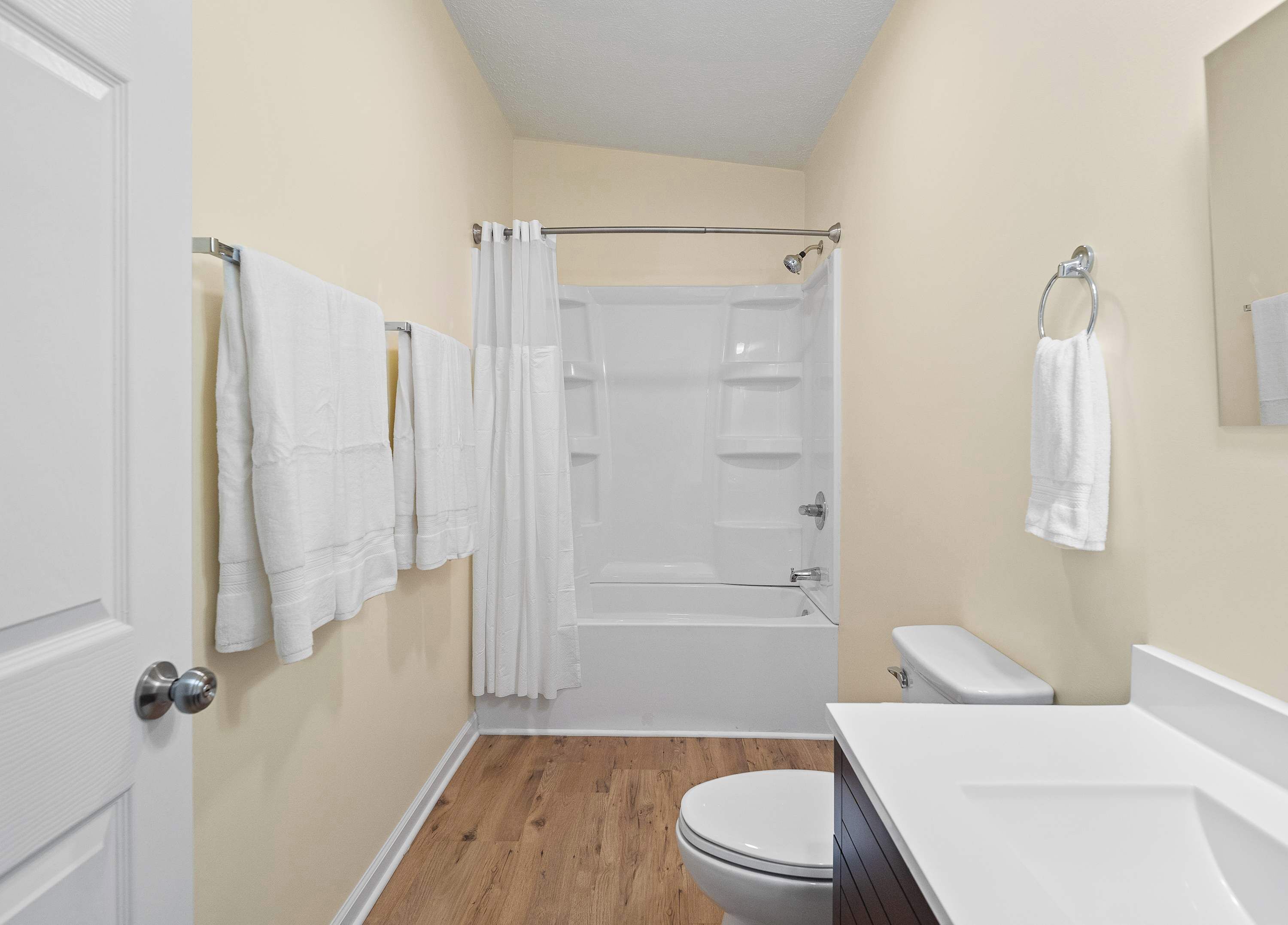 Un baño pequeño y limpio con ducha, inodoro y lavamanos.