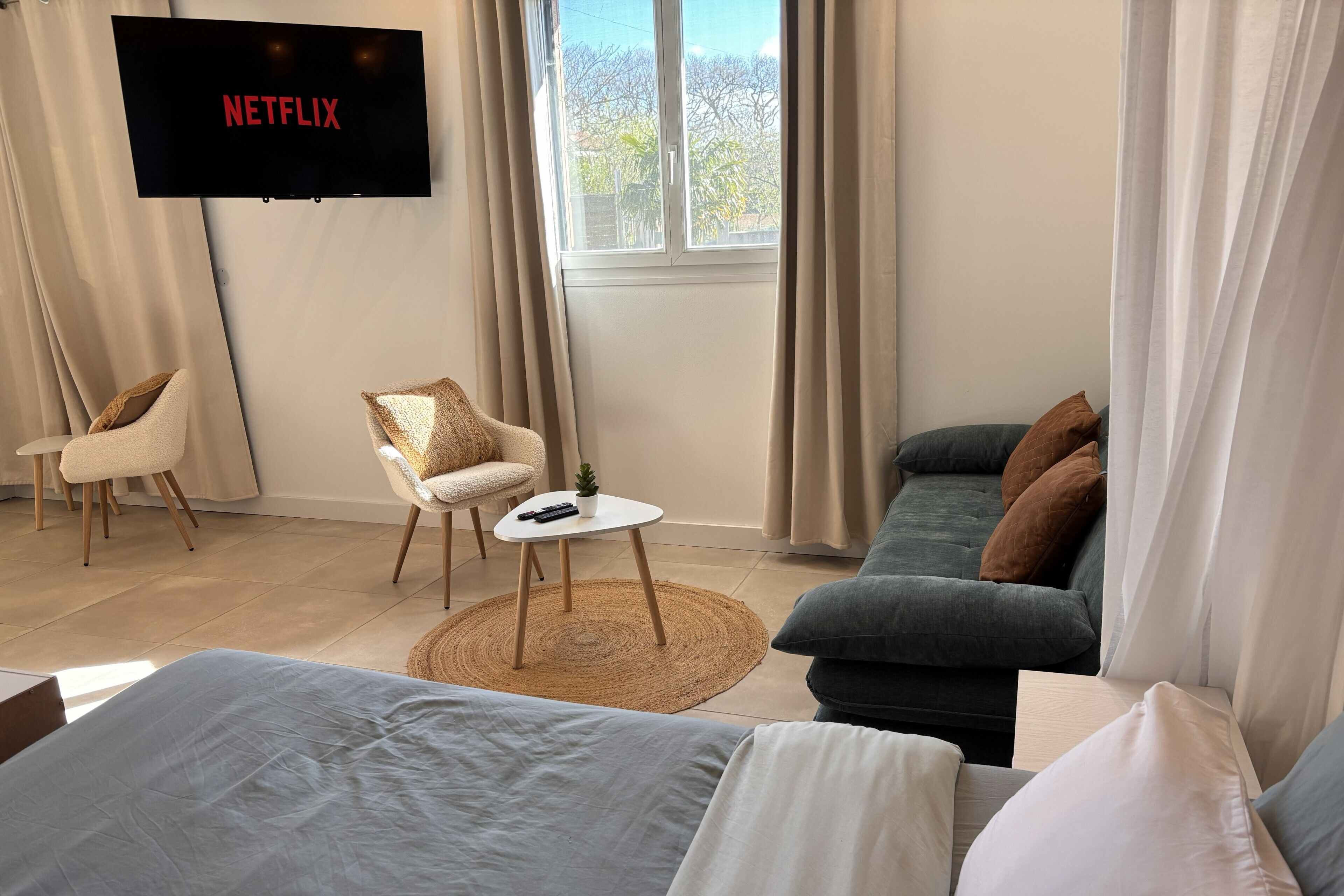 Un soggiorno moderno con TV a parete, un divano, una poltrona e un tavolino.