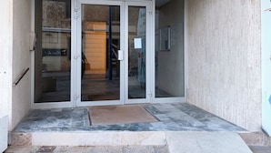 Une entrée d’immeuble avec une plaque indiquant « Résidence Sévigné B » et une porte numérotée.
