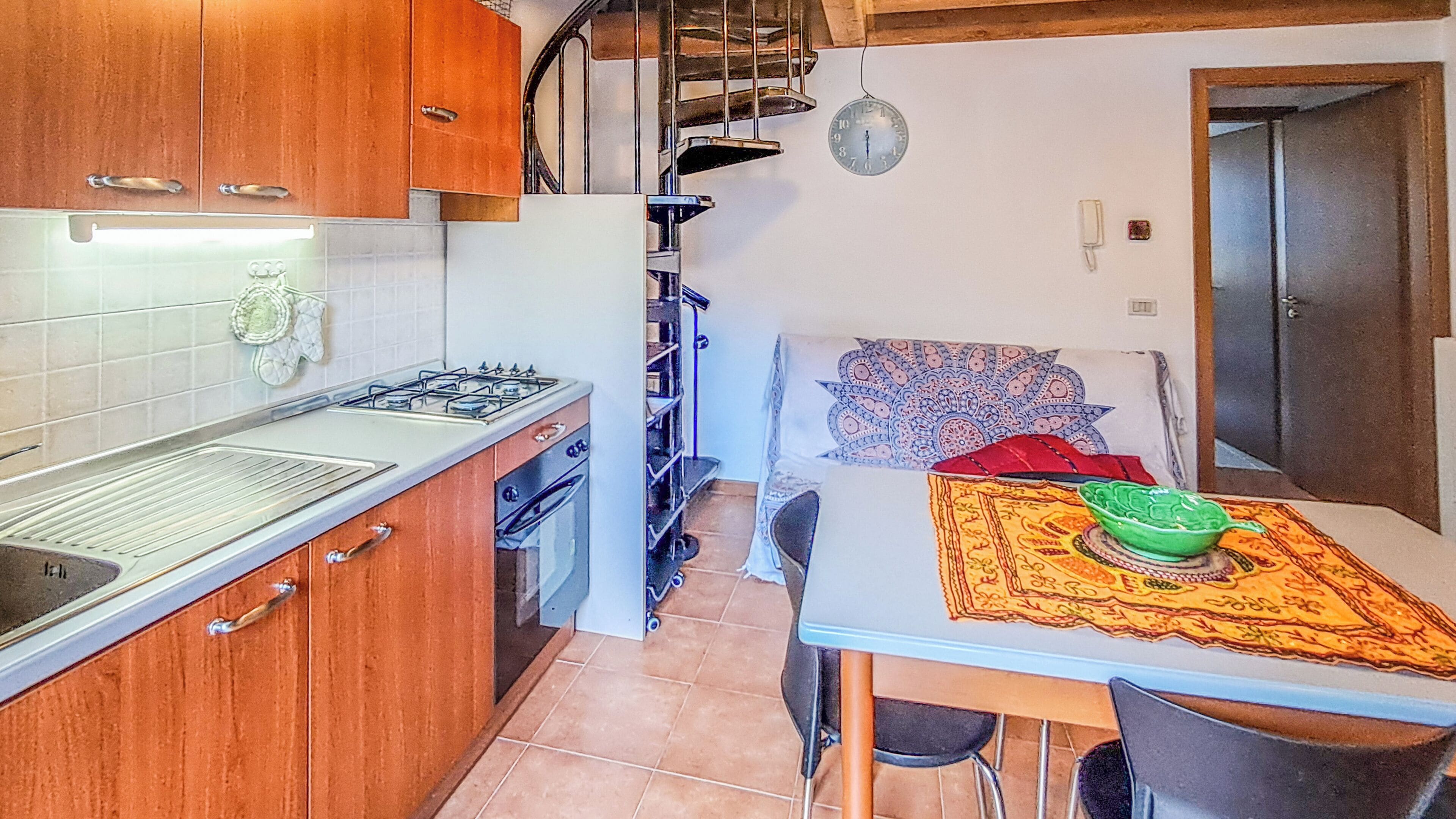A compact kitchen with a gas stove, oven, and a small dining area with a table and chairs.