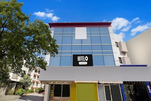 A hotel building with a sign reading 'HOTELO' and a company service label.