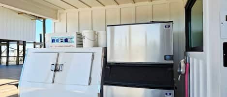 Una cocina con refrigerador de doble puerta, ventilador de techo y ventana con vistas.