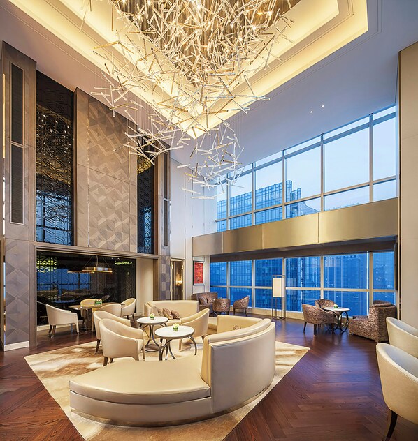 A spacious lobby with a modern chandelier, seating areas, and large windows offering city views. - Seaton International Hotel Chengdu (Chengdu)