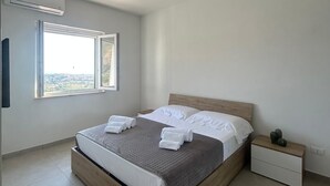 Un dormitorio moderno con una cama de madera, una mesita de noche y una ventana con vistas.