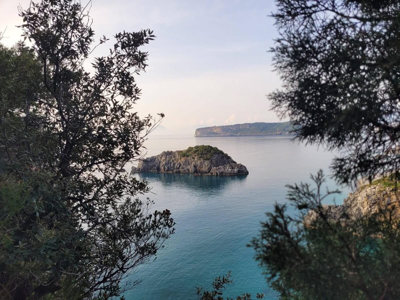 A coastal landscape with a rocky island and calm sea.