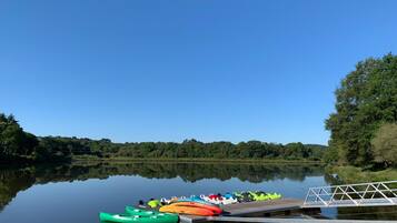 Un llac tranquil amb un moll i kayaks.