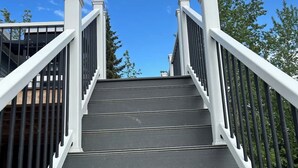 Eine Treppe mit weißen Geländern, die zu einem Gebäude führt.