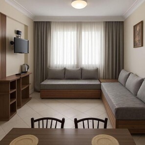 A modern living room with a sofa, a TV mounted on the wall, a coffee table, and a dining table with chairs. - Isni appart hotel (Agadir)