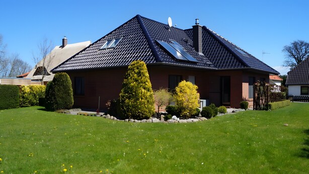 A modern house with a sloped roof, solar panels, and a well-maintained lawn. - Wittow Apartment for 2 Guests (50 m²) in Wiek on Rügen (Wiek)
