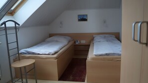 A dormitory room with two beds, a ladder, a small table, and a skylight. - Wittow Apartment for 2 Guests (50 m²) in Wiek on Rügen (Wiek)