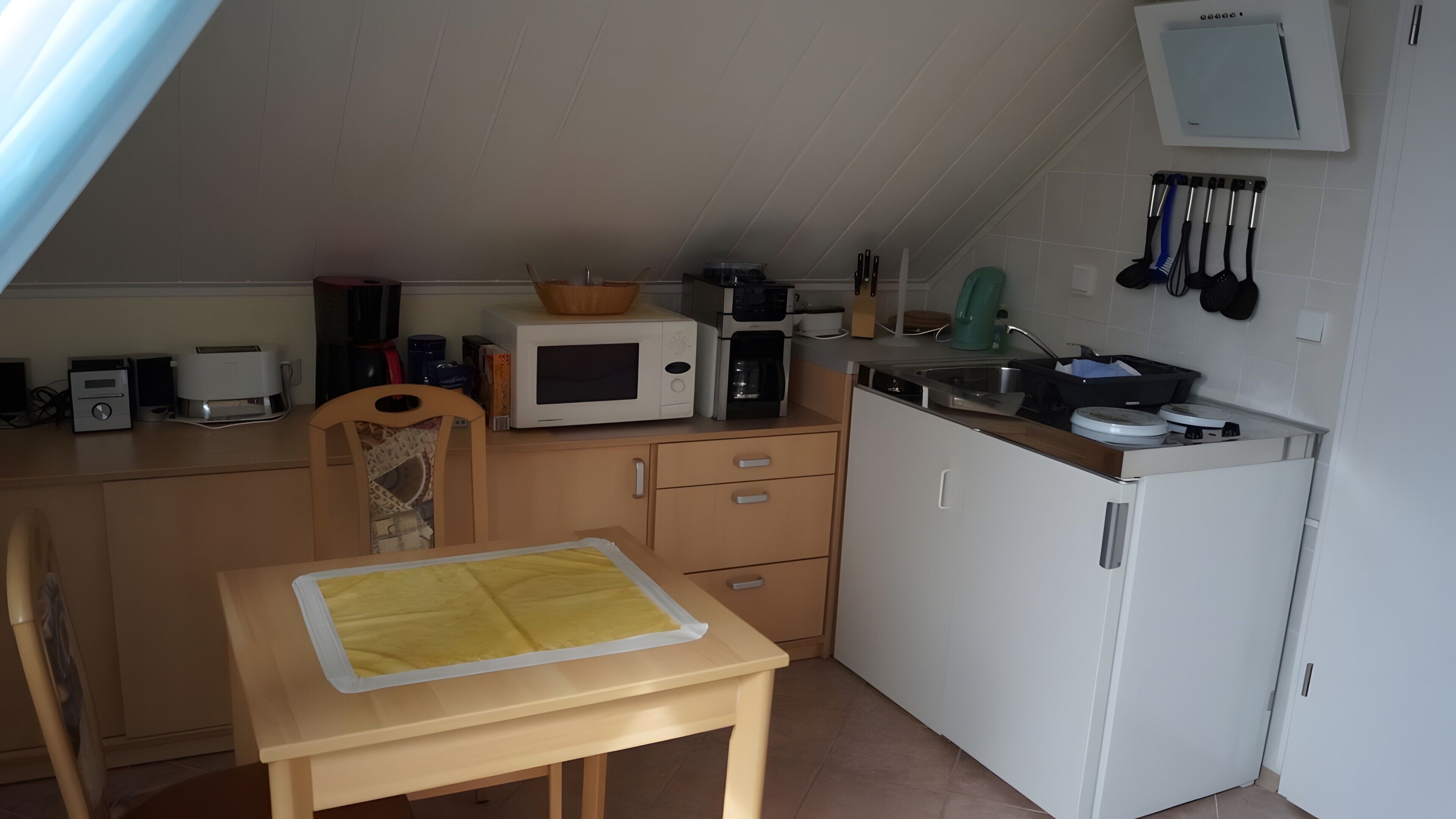 Eine kleine Küche mit einer Mikrowelle, einer Kaffeemaschine und einem kleinen Kühlschrank.