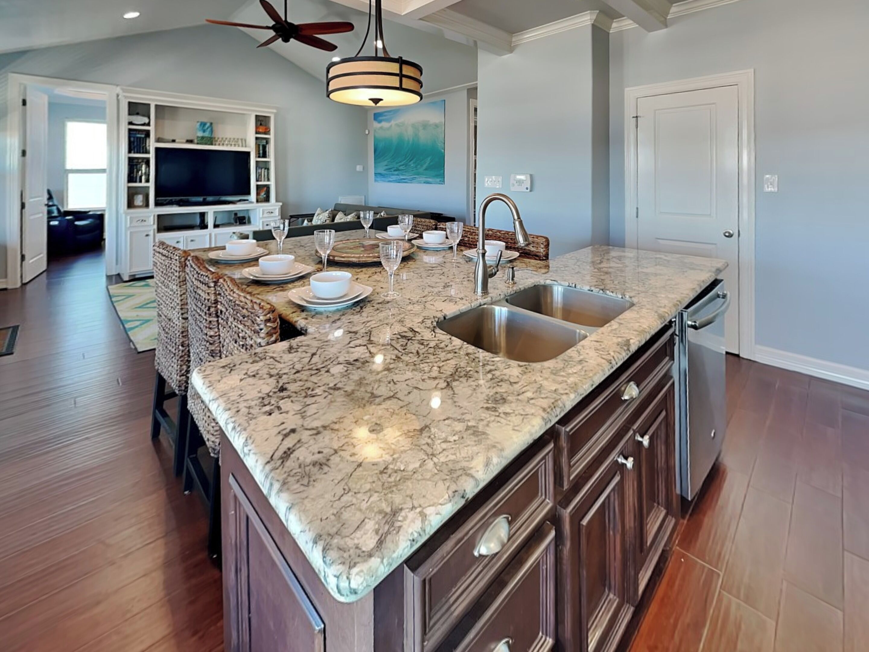 A spacious kitchen with a marble countertop, double sink, and built-in cabinetry.