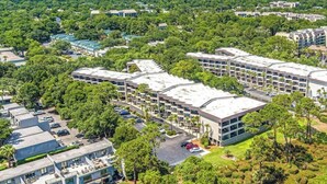 Un complesso alberghiero moderno con diversi edifici, aree di parcheggio e vegetazione circostante.