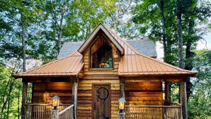 A wooden cabin with a front porch, a central door, and two windows. - Elk & Embers Mountain Hideaway (Waynesville)