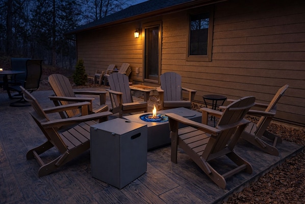 Un espace extérieur aménagé avec des chaises Adirondack et un foyer.