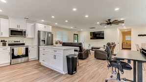 A modern kitchen with white cabinets, stainless steel appliances, and a central island.