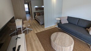 Ein modernes Wohnzimmer mit einer Couch, einem Couchtisch und einem Fernseher.