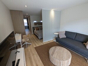 Ein modernes Wohnzimmer mit einer Couch, einem Couchtisch und einem Fernseher.